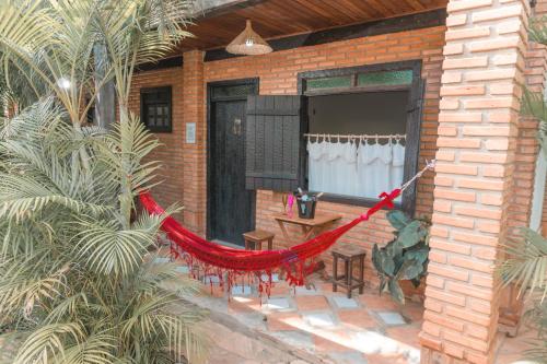 a red hammock on the outside of a house at Pousada Adega Cipo in Serra do Cipo