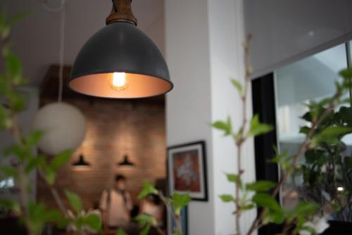 une lumière noire suspendue à une pièce ornée de plantes dans l'établissement Boy apartment -Adult only, à Hualien