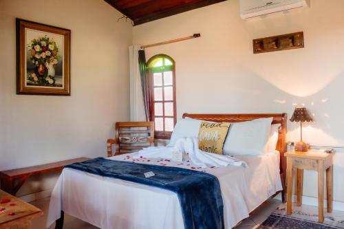 a bedroom with a bed and a window at Pousada Adega Cipo in Serra do Cipo
