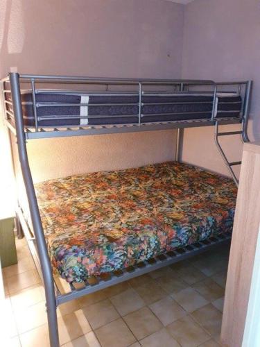 - un lit superposé avec un édredon floral sur la couchette inférieure dans l'établissement JARDINS DU CAP Joli T2 avec piscine Plage Richelieu Cap d'Agde, au Cap d'Agde