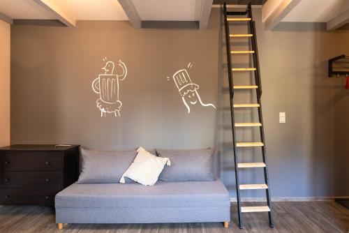 a living room with a couch and a ladder at Apartmány v lomnickém pivovaru in Lomnice nad Popelkou