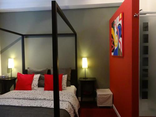 a bedroom with a black canopy bed with red pillows at B&B Welcome To My Place in Brussels