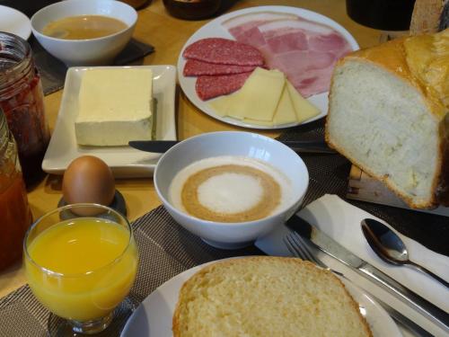 una mesa con platos de comida y un tazón de café y pan en B&B Welcome To My Place en Bruselas