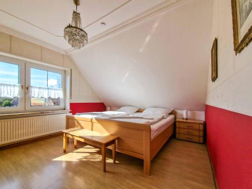 a bedroom with a bed and a red wall at Wassergans in Greetsiel