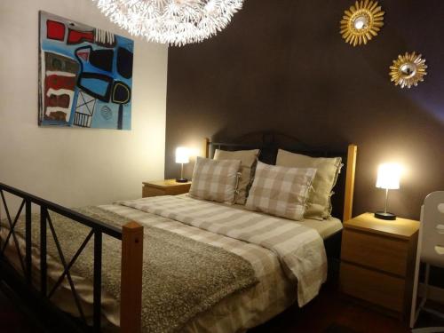a bedroom with a bed with two lamps and a chandelier at B&B Welcome To My Place in Brussels