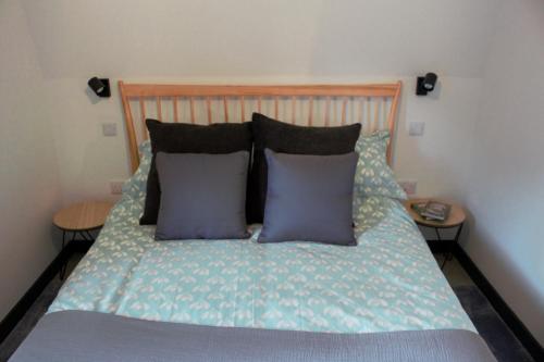 a bed with two pillows on it with two tables at Tigh Na Beithe in North Ballachulish