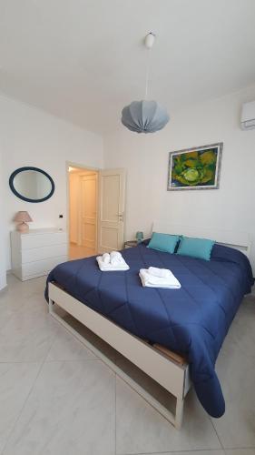- un grand lit bleu dans une chambre blanche dans l'établissement Casa Publicola, à Rome