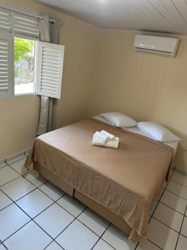 a bedroom with a bed with two towels on it at Pousada Manaíra in João Pessoa