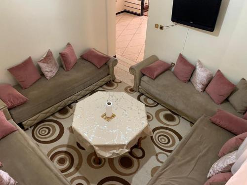 ein Wohnzimmer mit 2 Sofas und einem Tisch in der Unterkunft Appartement meublé à louer in Meknès