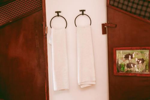 dos toallas colgando en una pared al lado de una puerta en Ngorongoro Camp and Lodge en Karatu