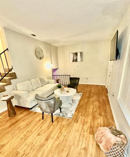 a living room with a white couch and a table at Spring Getaway 5 minutes from Hospitals in Jackson