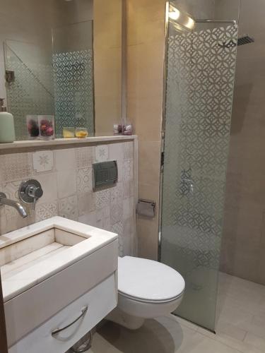 y baño con aseo y ducha acristalada. en Appartement La Perle en Marrakech