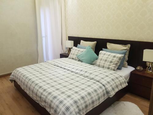 1 dormitorio con 1 cama con manta y almohadas a cuadros en Appartement La Perle en Marrakech