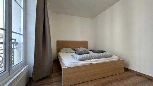 une chambre avec un lit dans une pièce avec une fenêtre dans l'établissement Le Chic Urbain, à Paris