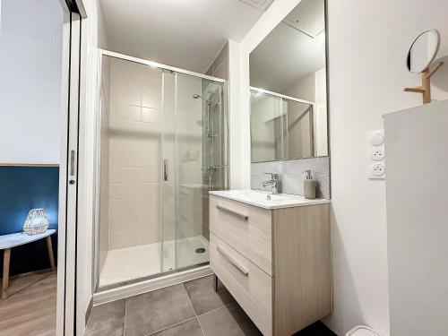 une salle de bain avec un lavabo et une douche dans l'établissement *L'Armorique* ravissant appartement cosy, à Brest
