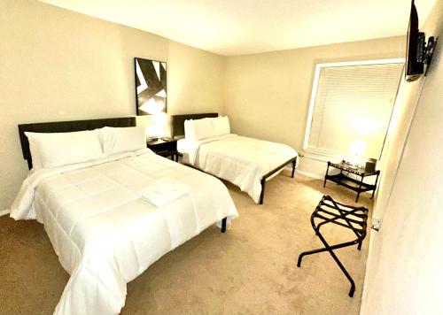 a hotel room with two beds and a window at Fondren Summer Getaway 5 Minutes to Major Hospitals in Jackson