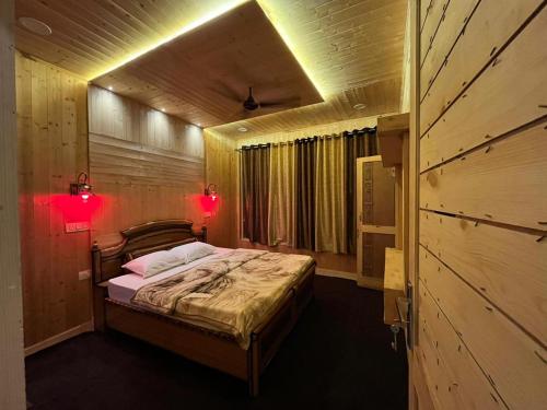een slaapkamer met een bed met twee verlichting bij RIGVEDA Bir Billing in Bir