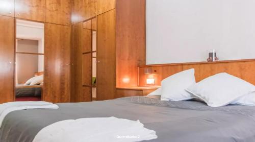 una camera da letto con un letto con cuscini bianchi di AA la Nueva Fe a Valencia