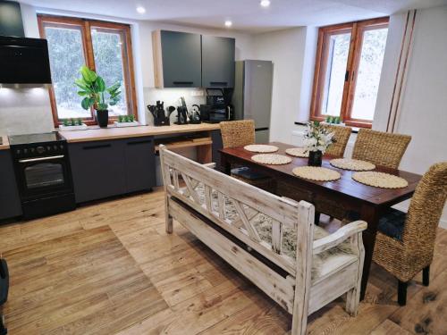 cocina con mesa de madera y comedor en Chata pod lesíkom, en Lazisko