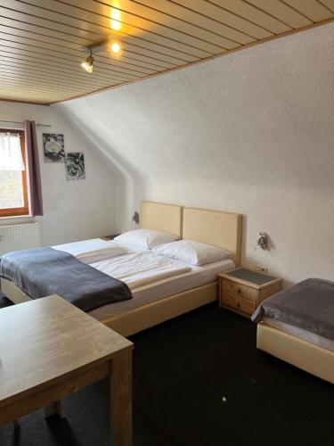 um quarto com duas camas e uma mesa em Pension Unterreichenbach em Schwabach