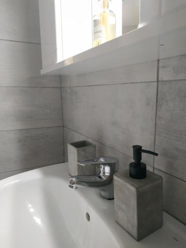a bathroom sink with a faucet and a bottle of soap at Maison Jolie in Vlachopoulátika