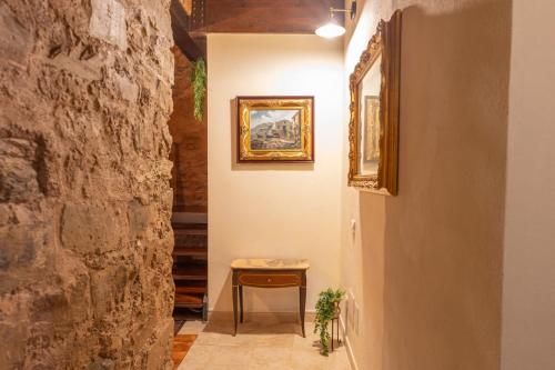 um corredor com uma mesa e um quadro na parede em B&B Città Regia em Iglesias