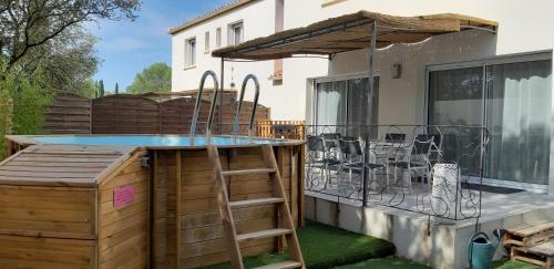 une terrasse avec une piscine et une table sur un balcon dans l'établissement La maison des Cigales, à Montferrier-sur-Lez