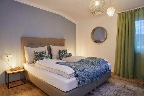 a bedroom with a bed and a green curtain at Beachvilla Velden in Velden am Wörthersee