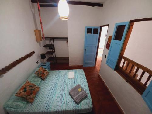 Cette chambre comprend 2 lits et une porte bleue. dans l'établissement Casa Hostal Colonial VaraEchada, à Barichara