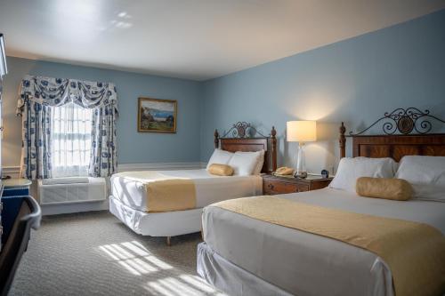 a hotel room with two beds and a window at Dan'l Webster Inn and Spa in Sandwich