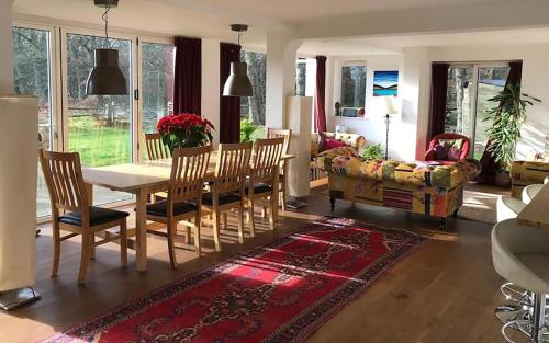 a living room with a table and chairs and a couch at A House in the Woods in Chiddingly