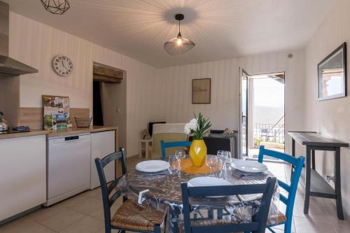 a kitchen and dining room with a table and chairs at Les Lauriers d'Aimée pour 4 pers in Mirabel-et-Blacons