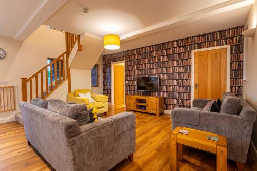 a living room with two couches and a tv at Bullrush Barn, Brecon Beacons walkers retreat in Brecon