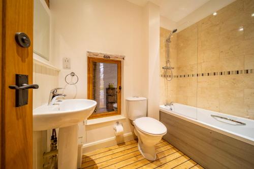 a bathroom with a sink and a toilet and a tub at Bullrush Barn, Brecon Beacons walkers retreat in Brecon