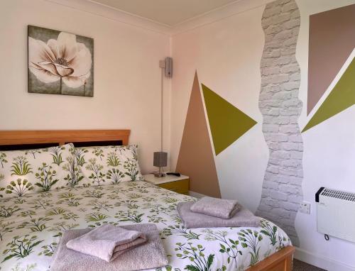 a bedroom with a bed and a stone wall at Corton Villas in Lowestoft