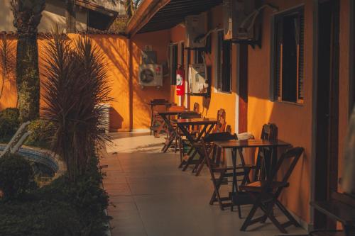 a row of tables and chairs in a restaurant at Pousada Acqua Bella PISCINA CLIMATIZADA in Bertioga