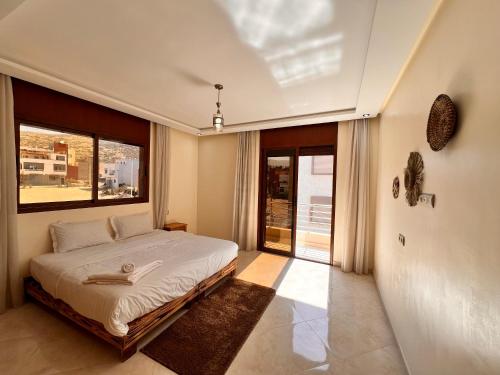 a bedroom with a bed and a large window at Golden WAVE IMSOUANE in Imsouane