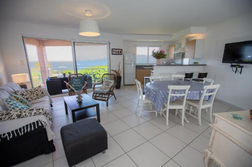 un salon avec un canapé, une table et des chaises dans l'établissement Résidence Pietri, à Calcatoggio