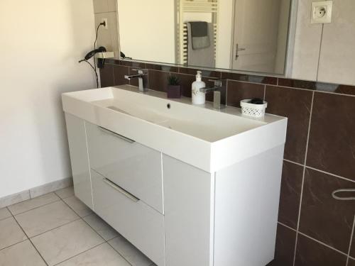 une salle de bain avec un lavabo blanc et un miroir dans l'établissement Villa Firenze, à Montségur-sur-Lauzon