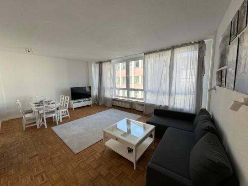 een woonkamer met een zwarte bank en een tafel bij Ruhrgebiet-Apartments in Duisburg Stadtmitte in Duisburg