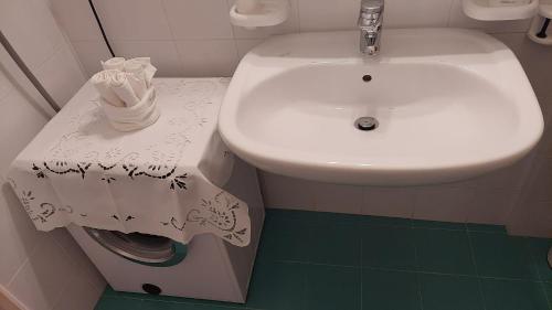 a bathroom with a white sink and a roll of toilet paper at Residence Milcar in Chiesa in Valmalenco