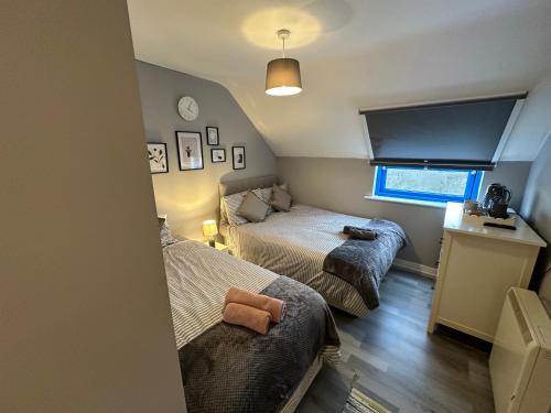 Wembley Serviced Apartment, 20mins from Central London في لندن: غرفة نوم صغيرة بسريرين ونافذة