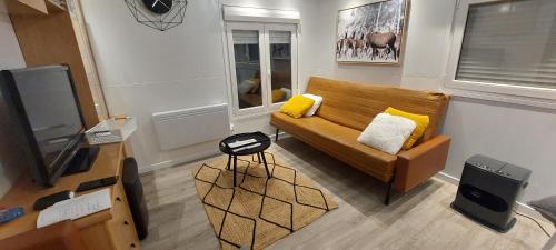 a living room with a couch and a television at Mobil home dans camping in Saillagouse