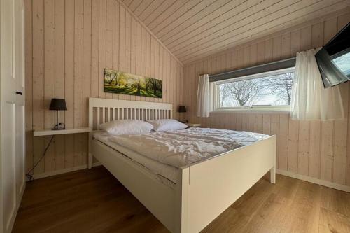 a bedroom with a large bed and a window at Ferienhaus mit Pool und Sauna am Dümmer See, Dümmer in Dümmer