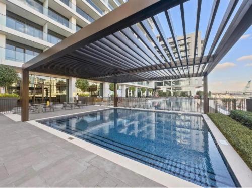 a swimming pool in a building with awning at Palace Dubai Creek Harbour Residences Skyline Apartment in Dubai
