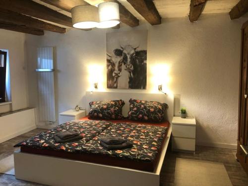 a bedroom with a bed and a picture of a cow at Fachwerkhaus Kürbis Bacharach in Bacharach