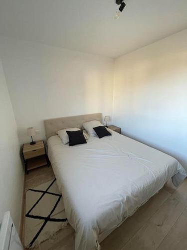 a bedroom with a large white bed with two pillows at Maison mitoyenne 60m2 en campagne in Montailleur