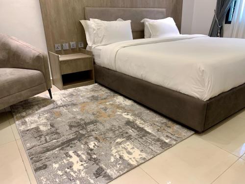 Polo Grand Hotel في Maiduguri: غرفة نوم بسرير كبير وأريكة