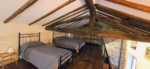 a attic bedroom with two beds and a brick wall at Historical House Medieval Abbey - Al Chiostro in Sotto il Monte