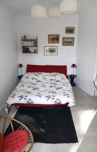 a bedroom with a bed with a black and white comforter at Charmant petit studio avec jardin et piscine in Nîmes